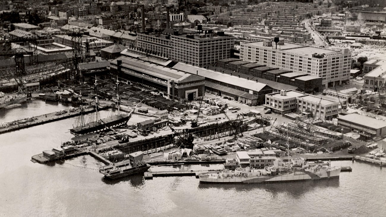 Aerial view of the Charlestown Navy Yard and its piers; USS Constitution is docked at the Navy Yard.